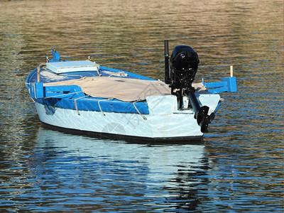 最佳小型木驳船外舱发动机漂浮在蓝色环礁湖波中木制的引擎图片