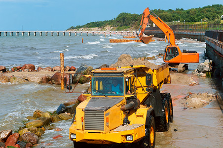 卡车岸上施工设备防波堤施工海岸保护措施上工设备防波堤施工墙运输背景图片