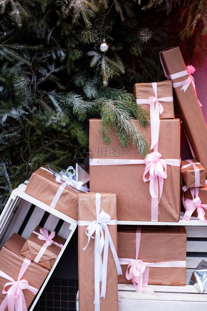 庆祝12月5日在靠近圣诞树和杉木节新年概念墙的街道上制作礼品盒展示纸图片