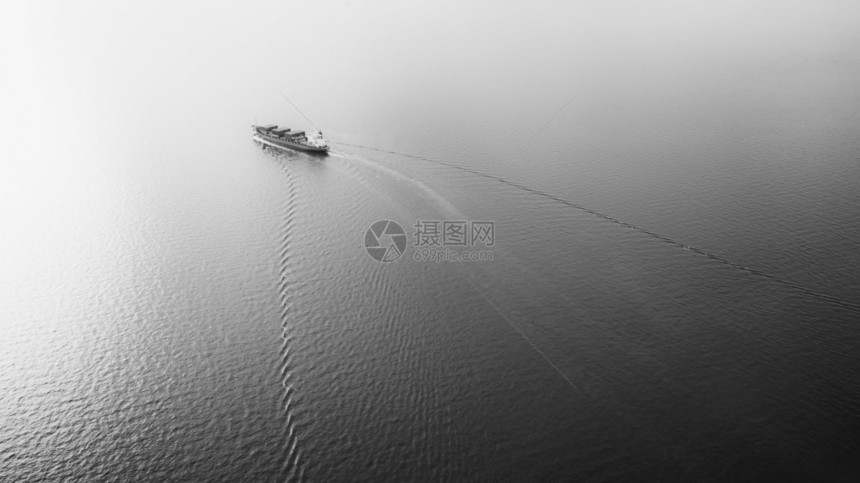 在海上航行的黑白小型集装箱船舶和美丽的波纹海浪背景抽象空中观光的背景情况以及国际的进口条纹图片