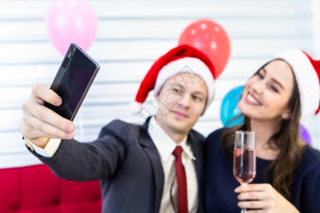 新年20概念快乐幸福夫妇的自拍在圣诞节和新年树夏夜晚会期间握着香槟杯在完成商业工作后圣诞树背景下庆祝爱典背景图片