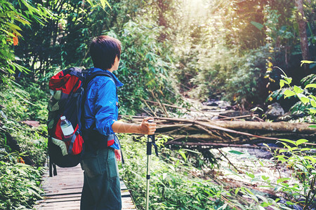 背包客带着穿过山河在森林中行走的人在森林里徒步登山旅行极端图片