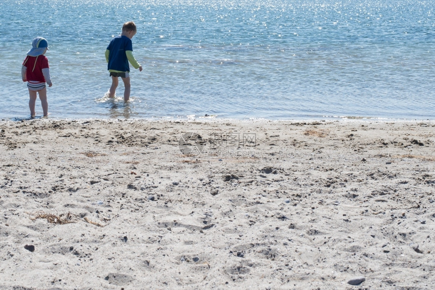 自然两个小孩在海滩玩两个小孩在海滩上玩浅水边轮廓兄弟图片