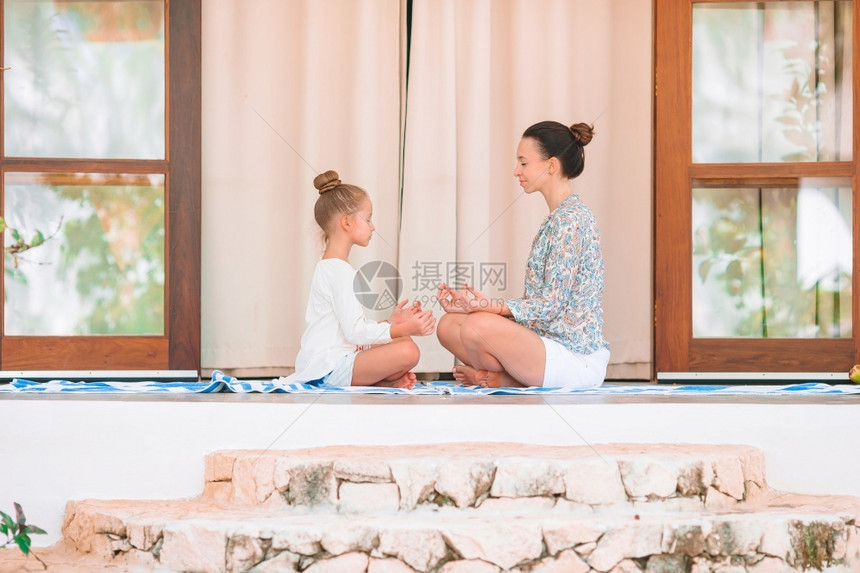 打坐爱和平母亲女儿在阳台上冥想户外在阳台上做瑜伽锻炼在阳台上快乐的年轻家庭沉思图片