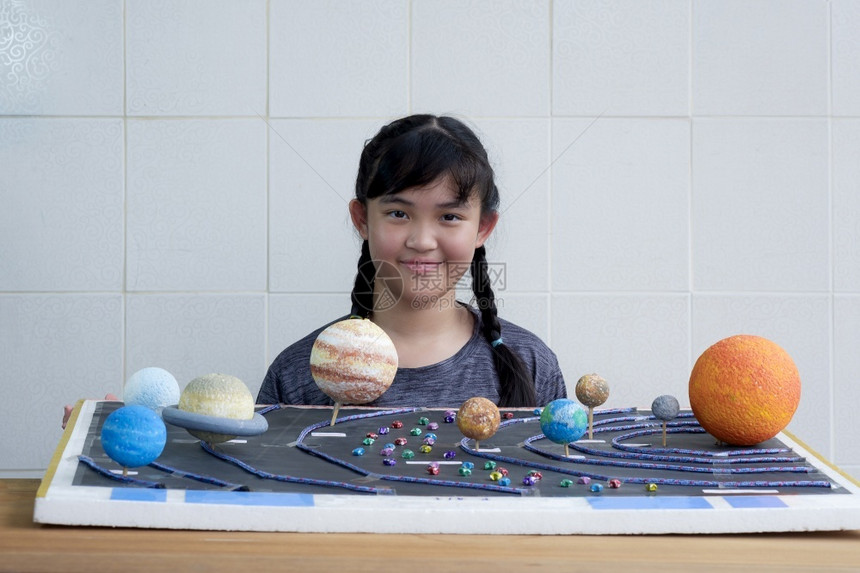 创造力行星年轻笑的亚洲女孩展示她的自制太阳系模型在Schoo科学家庭作业项目初级图片