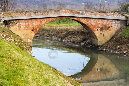 砖砌横跨反射水的旧小砖桥自然景观图片