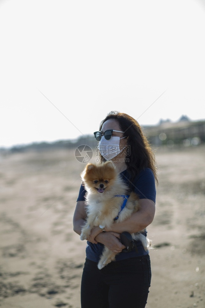 愉快年轻女子和她的狗在海滩上晒日光浴女孩火鸡图片