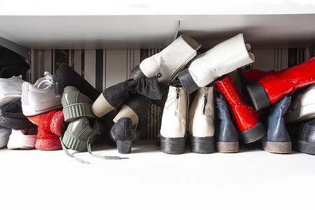 女士为了在鞋架中收集不同的旧鞋用于存放凌乱和需要整理在室内设计中带架子的衣柜有复制空间垃圾摇滚背景图片