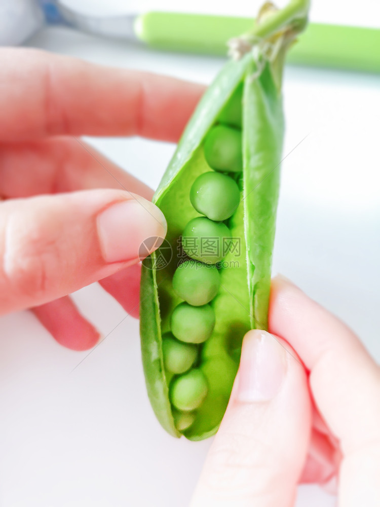 种族青年妇女轰新鲜青豆健康食品和生活方式手指自然图片