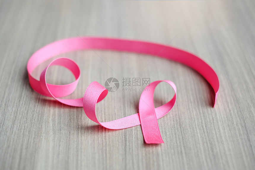慈善机构木制的乳腺癌认识关于木制背景的粉红丝带用于支持生活和患病者的妇女保健及世界癌症日概念妇女保健与世界癌症日概念治愈图片