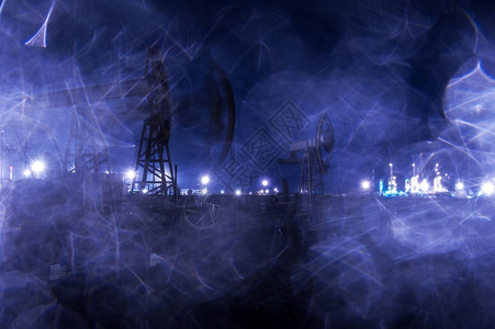 黄昏汽油晚上集体石钻井机和夜间照明的工业场地雨滴纹质通过湿玻璃粉蓝色图片