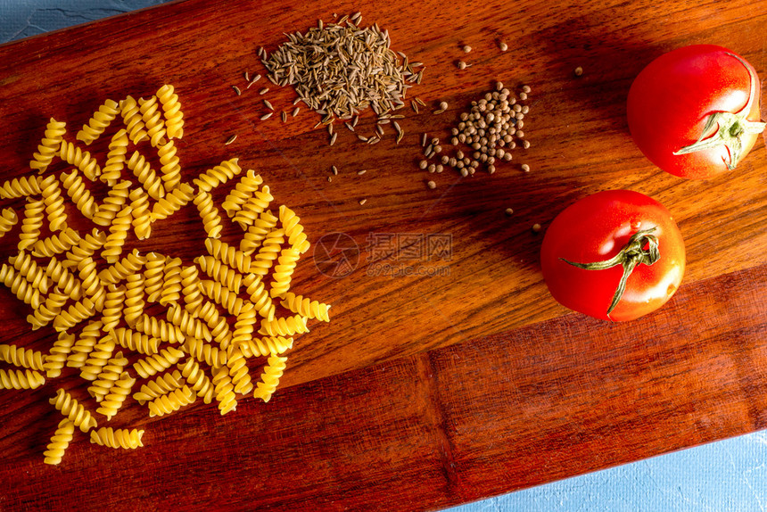 烹饪意大利面西红柿和厨房桌上的香料成分与意大利面番茄和香料一起切割板营养樱桃杂货店图片