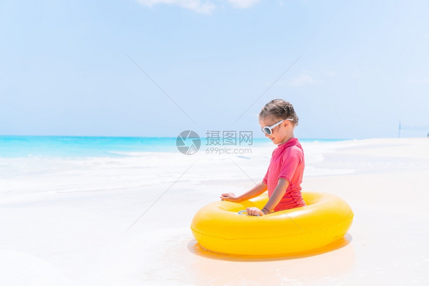 沙滩上小女孩坐在游泳圈里图片