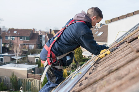 工人安全帽在屋顶上建造太阳能电池板的人造建筑师控制板图片
