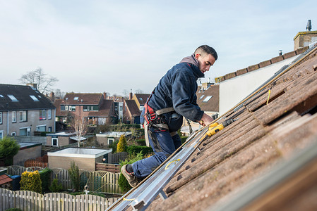 安全在屋顶上建造太阳能电池板的人造建筑师网格们高清图片