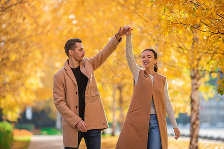 晴天友谊秋两家人在公园快乐秋天欢家庭在阳光明媚的季公园走在天乐趣图片