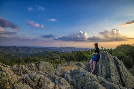 一个年轻女孩享受着从山顶上游到的美丽景色天空雄伟环境图片