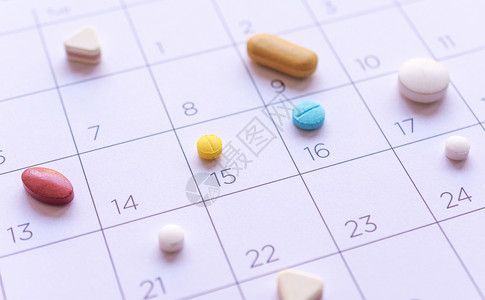 时间星期约定各种药片在日历背景概念上是不一样的健康护理图片