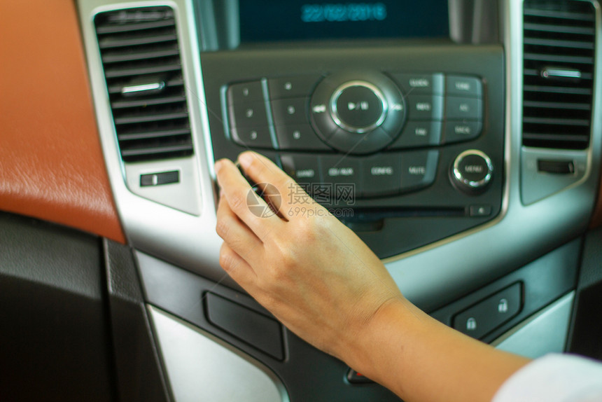 车辆亚洲女在汽车收音机上监听乐的按键护发素声音图片