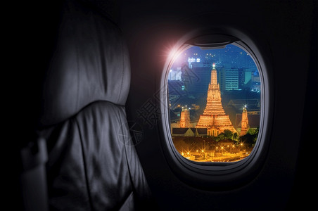 传统的天空灰色风向WatArun或黎明寺是泰国惊人的建筑里程碑旅行和空中运输概念以及旅行和运输概念的内地飞机视WatArun为窗背景图片