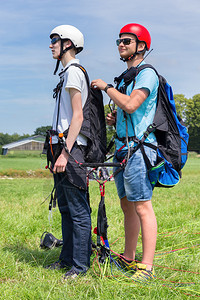 没课风跳伞者娱乐与男孩一起准备同步飞行的滑翔教练员头盔背景