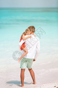 父亲和小女孩在沙滩度假图片