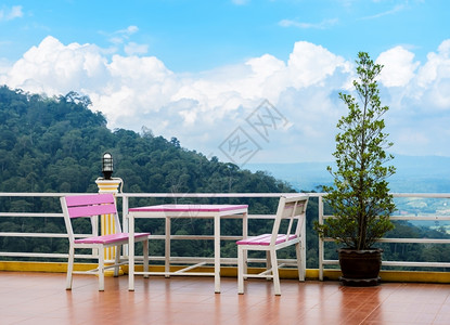 栅栏户外鉴于山地背景露天白色椅子和桌放在高压地板梯式露台上美丽的图片