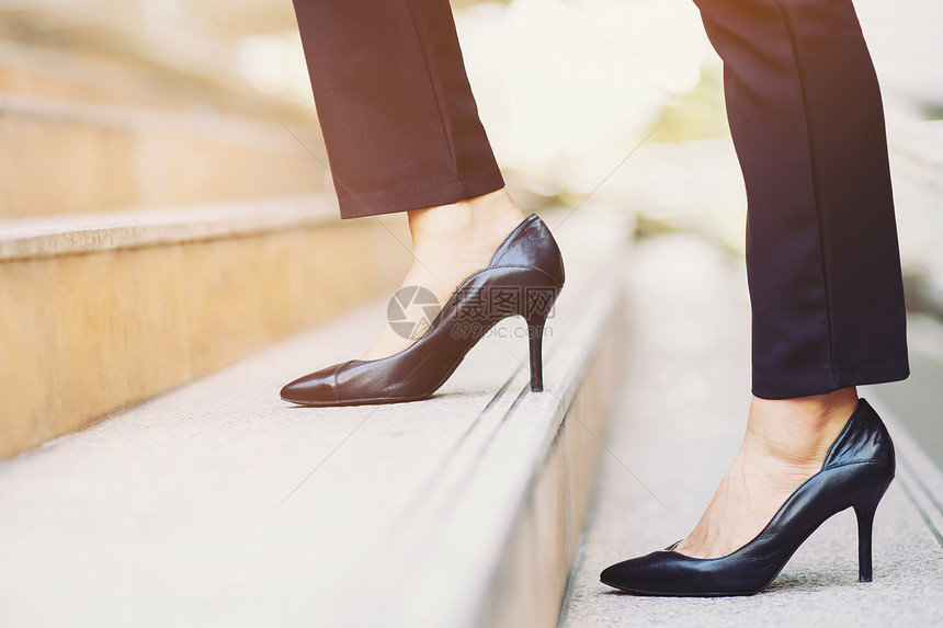 职业泰国在现代城市上楼梯的女商人紧合鞋腿脚踩成功图片