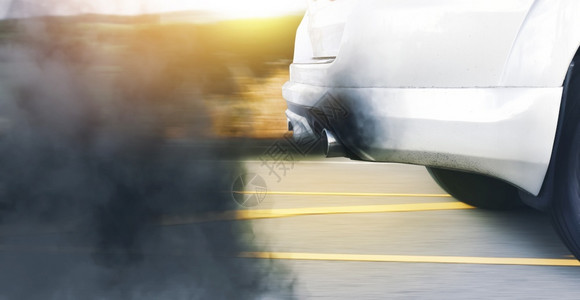 一辆汽车的空气污染上有过时的柴油机和路上黑烟以及雾色的驾驶背景图片