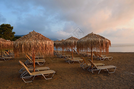 热带水平的美丽清晨海边滩的日落阳伞和甲板椅太图片