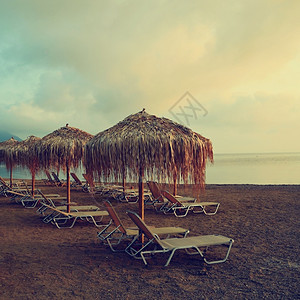 美丽的清晨海边滩的日落阳伞和甲板椅放松海岸线夏天图片