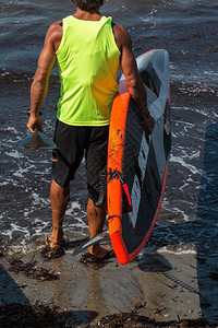 桨板娱乐在海中冲浪前人与他的上岸者在海中潜伏休闲的图片