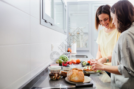 现代的两名妇女在厨房柜台准备健康食品饮和营养概念两名妇女享受午餐图片