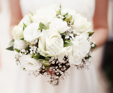 爱浪漫的花新娘拿着外面白玫瑰的花束图片