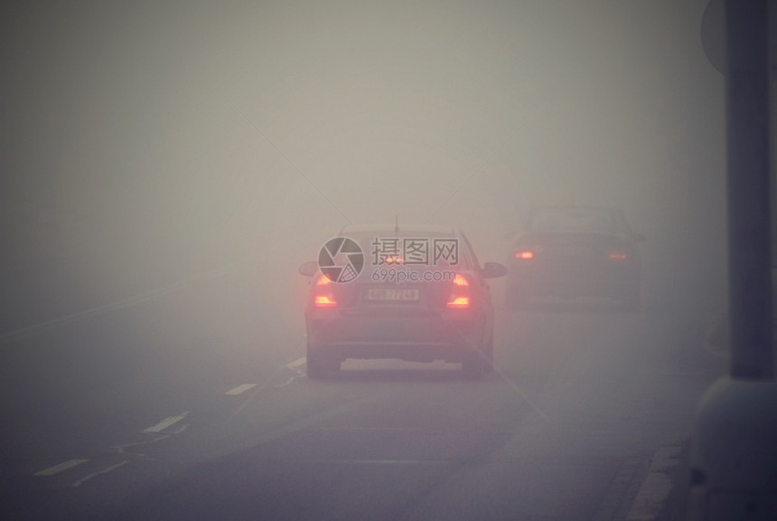 薄雾城市大灯冬季天气恶劣公路上的轻型车辆在雾中危险机动车交通情况也十分危险图片