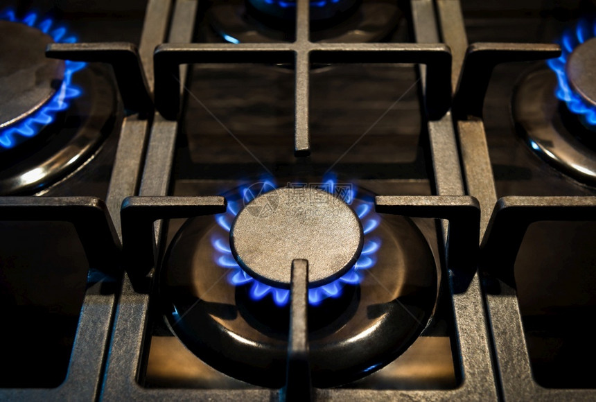 蓝色的热圆圈家用煤气炉装有燃烧的炉关闭火焰燃气炉图片
