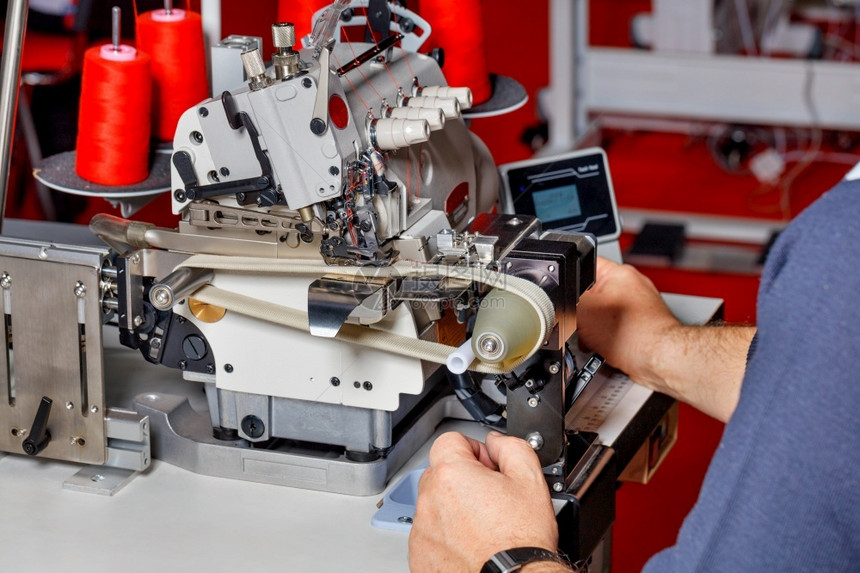机器缝衣生产手和工匠建立现代电动缝纫机检查其工作质量师傅调整现代电动缝纫机的工程a管理者对现代电动缝纫机的工作进行调整现代的接缝图片