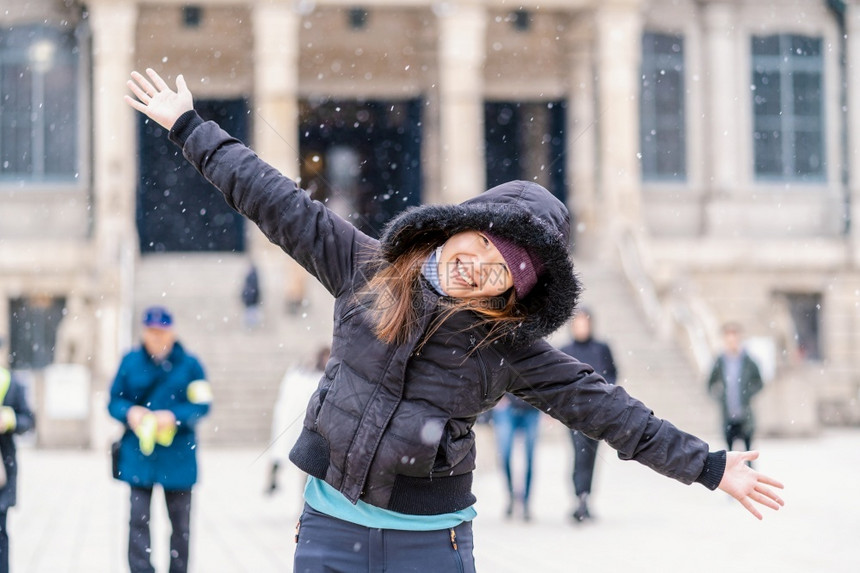 为了漂亮的成人下雪时玩的亚洲年轻女子旅行和兴奋的概念冬戴带毛帽披头巾和外套图片