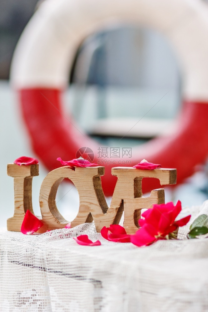 爱拯救了世界华伦人白昼在生命浮标的背景中在粉红玫瑰花瓣间刻下爱的木字户外生活抽象的图片