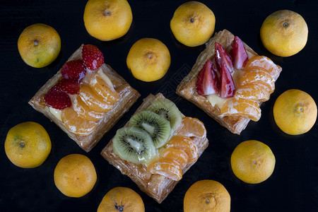 噗餐饮黑底带橘子kiwi和草莓果的松饼自由度图片