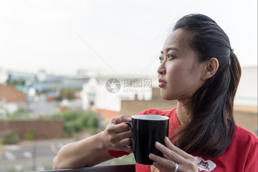 脸Yip年轻的亚洲女饮咖啡杯在与城市背景交融的点上喝咖啡外部衬衫图片