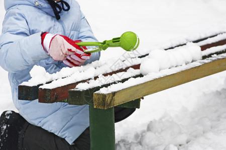 季节木制的冬游戏一个儿童坐在雪中一个旧长椅旁雕塑雪球的画面明亮图片