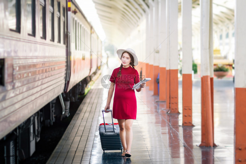 淑女幸福在火车站旅行中带红色手提箱的亚洲孕妇穿红衣旅行车站人类图片