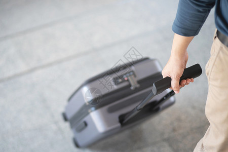 女士终端步行携带肩袋和手提行李的男子在机场行走图片
