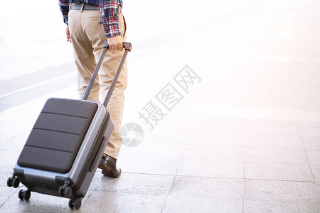 假期内部的携带肩袋和手提行李的男子在机场行走门图片