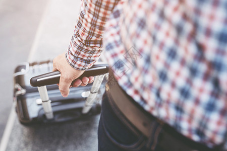 携带肩袋和手提行李的男子在机场行走内部的步旅游图片