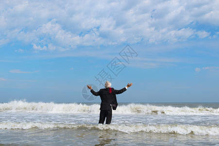 地平线赤脚领带身穿正式西装的商人在海上行走图片