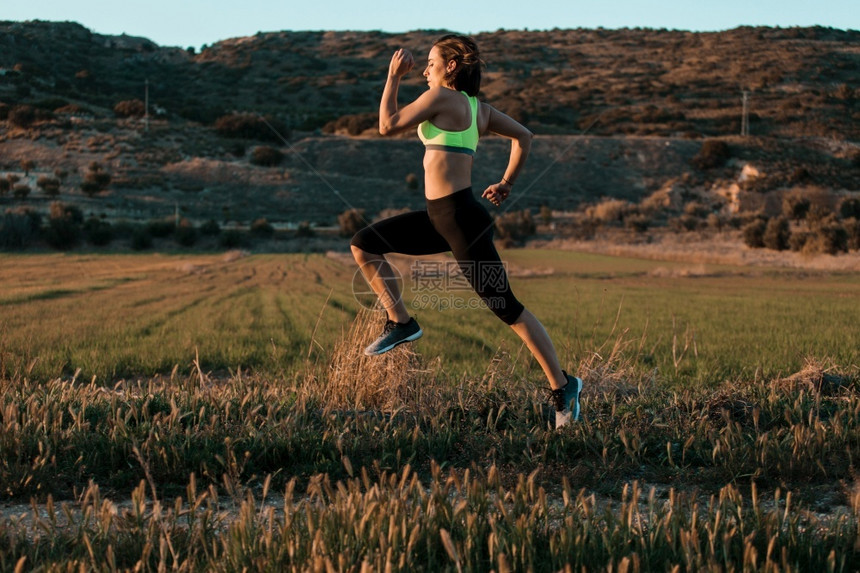 一种竞技女跑步者在春草林中自然界的锻炼运动娱乐图片