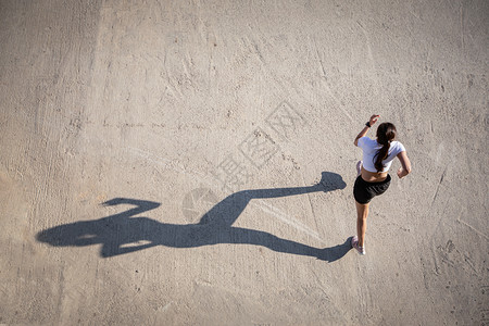 合身亚裔女在城市公路上跑步和的顶端景象健康最佳背景图片