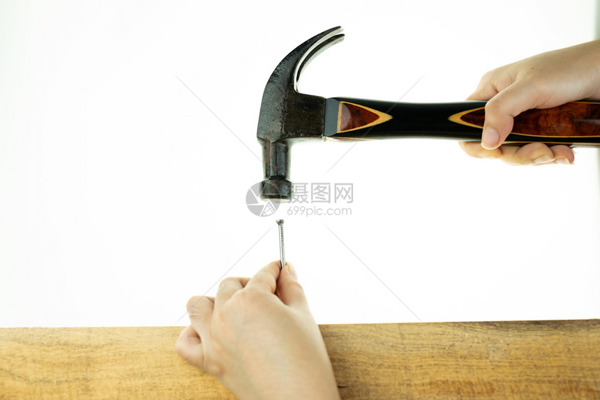 女士握手敲锤打钉子在白种背景的木头上作坊工艺装修图片